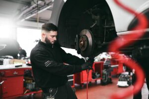 Bild zeigt Mechaniker beim Schrauben in einer Werkstatt