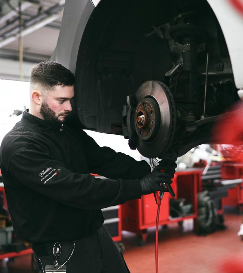 Bild zeigt Mechaniker beim Schrauben in einer Werkstatt